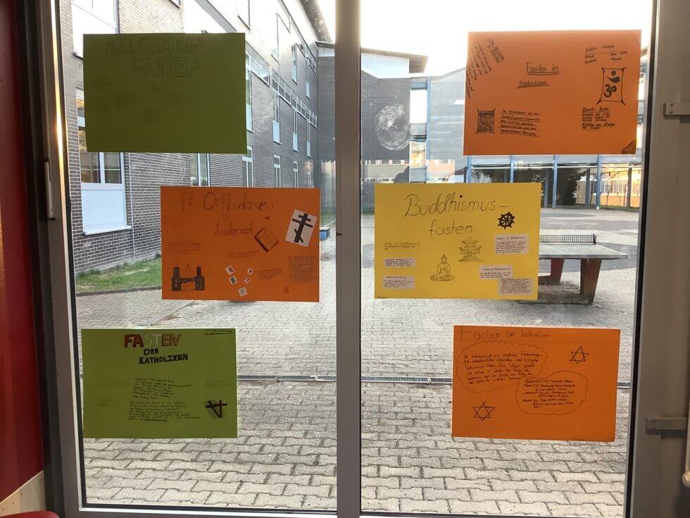 Schüler:innen und Lehrkräfte essen gemeinsam in der Schulmensa